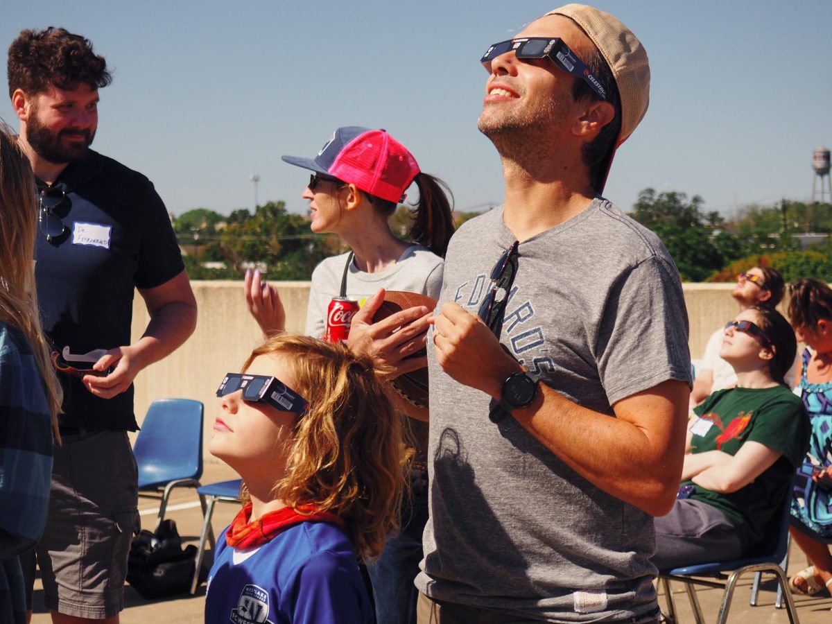 Parents+brought+their+children+to+St.+Edwards+to+view+the+eclipse.