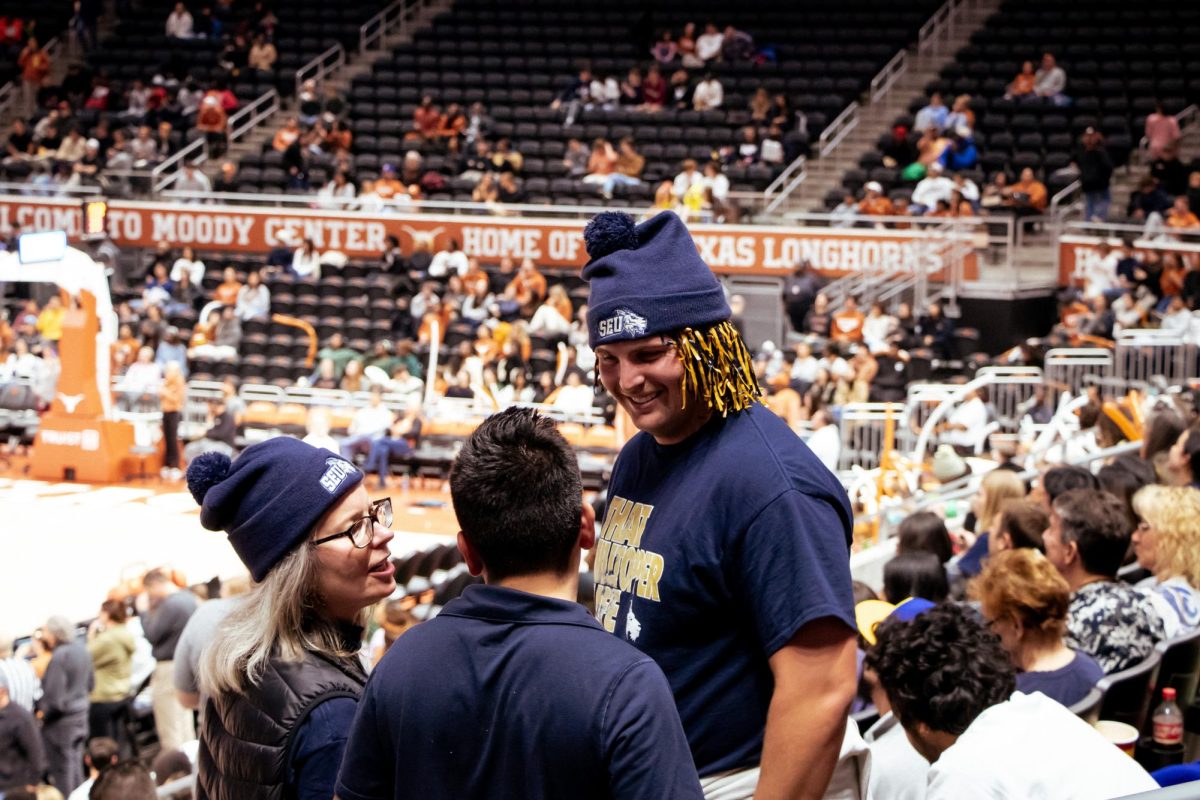 Dr. Lisa Kirkpatrick, Vice President of Student Affairs (left), SGA President Ethan Tobias (middle) and SGA Vice President Matthew Gerrets chat during the game. Kirkpatrick, Tobias, and Gerrets were all supporting the ST. Edwards mens basketball team.