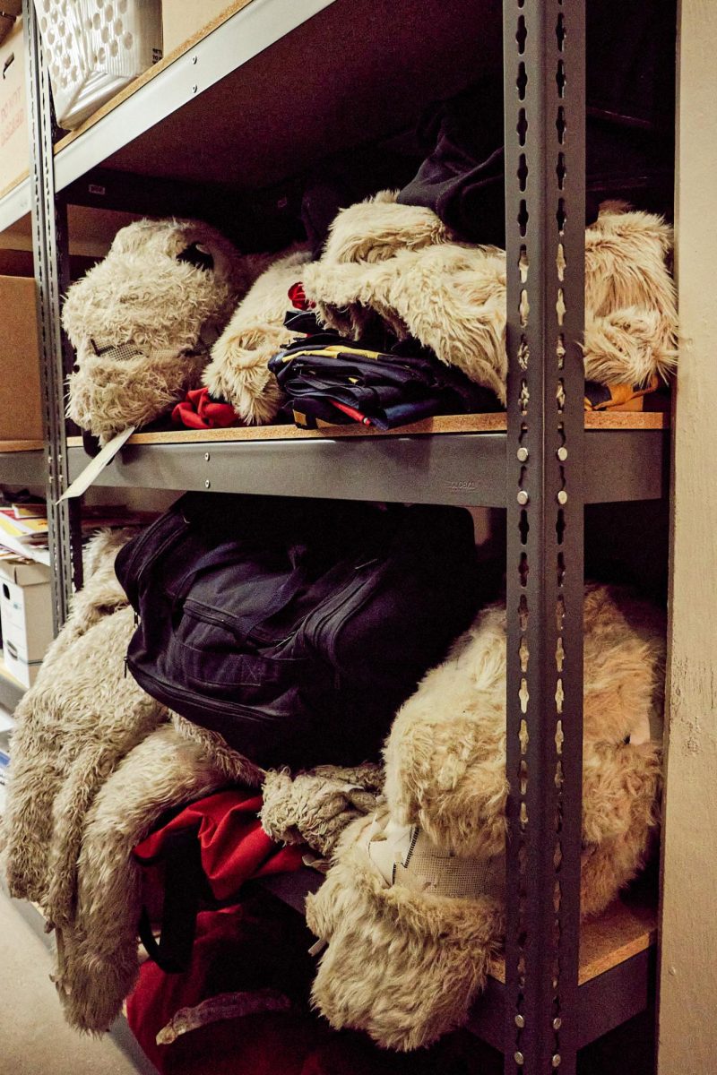 A collection of dated Topper uniforms sit upon a shelf inside of the archives department, a sentiment of homecomings past. 