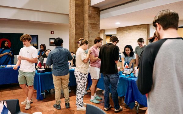 Various students lining up to taste the cultural delights at the club’s cultural showcase. In this corner of the Moody Atrium, tables featured cuisine from Qatar, Korea, Bangladesh, Japan, France and Tanzania. Katya Riviera (center), can be seen giving a presentation about the Japanese chicken curry she prepared. 