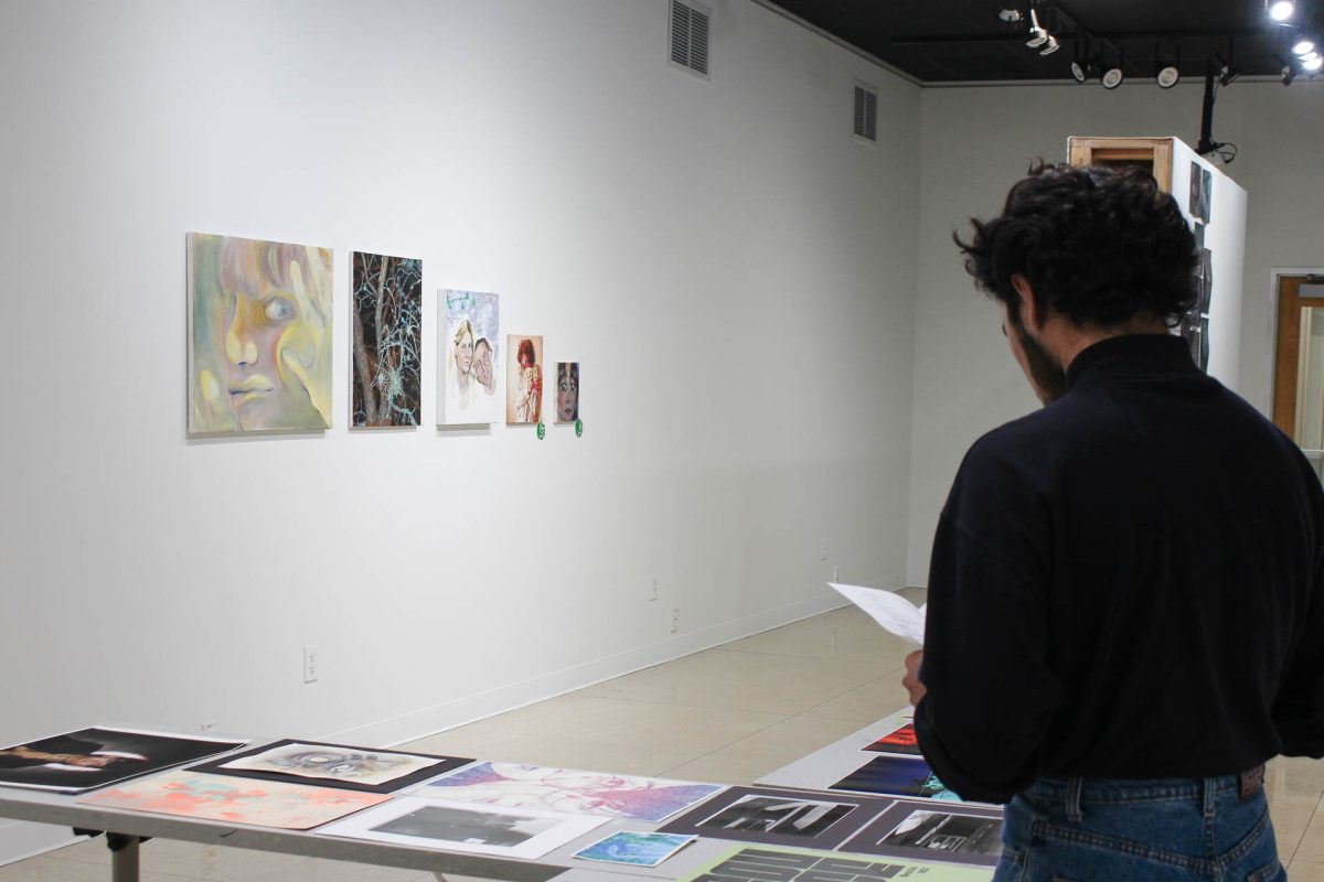 Daniel Mendoza looking at his and his peers’ artwork.