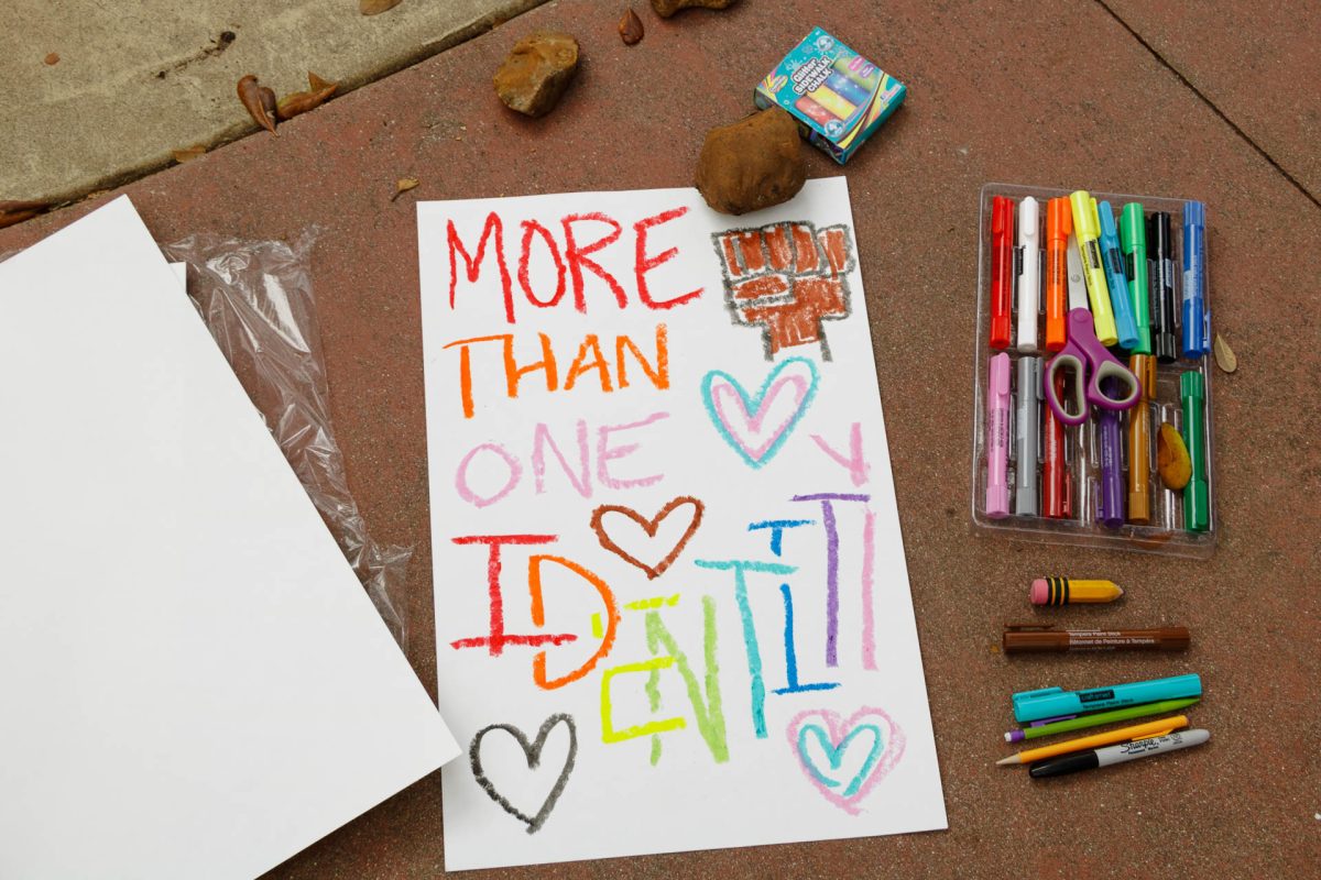 A hand-written protest sign lays on the ground on the seal. Students brought their own creative tools to make signs during the protest.