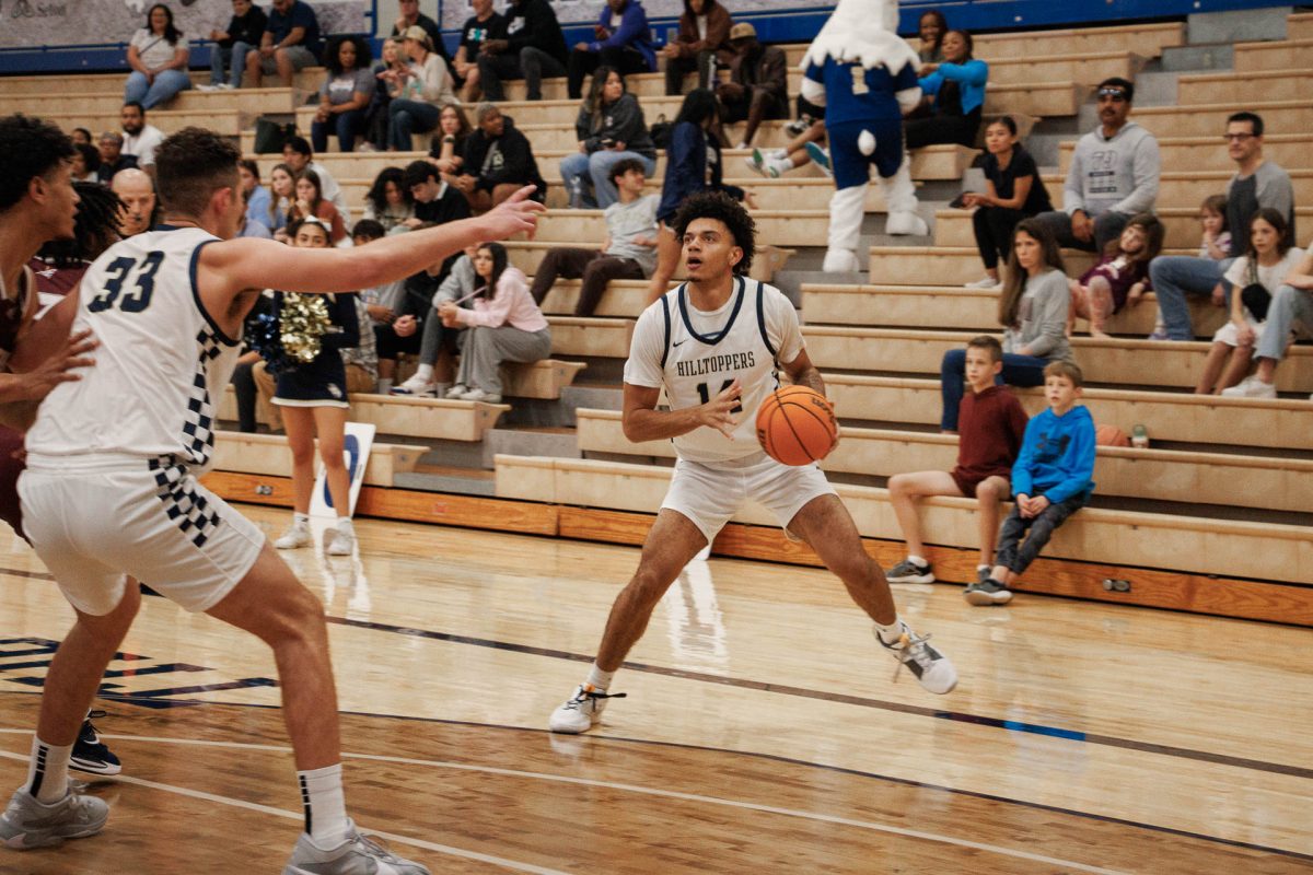 Junior guard Jayden Johnston prepares to attempt a three-pointer. Sophomore center Sean Elkinton blocks the Dustdevils defense to leave him open to shoot. Johnston had a total of eight points and four rebounds. 