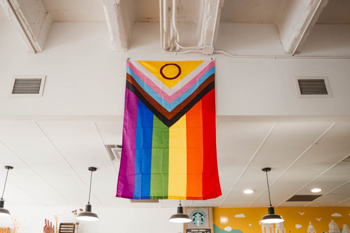 The+new+Progress+flag+hanging+in+Meadows+Coffee%2C+representing+the+LGBTQ%2B+community+on+campus.+