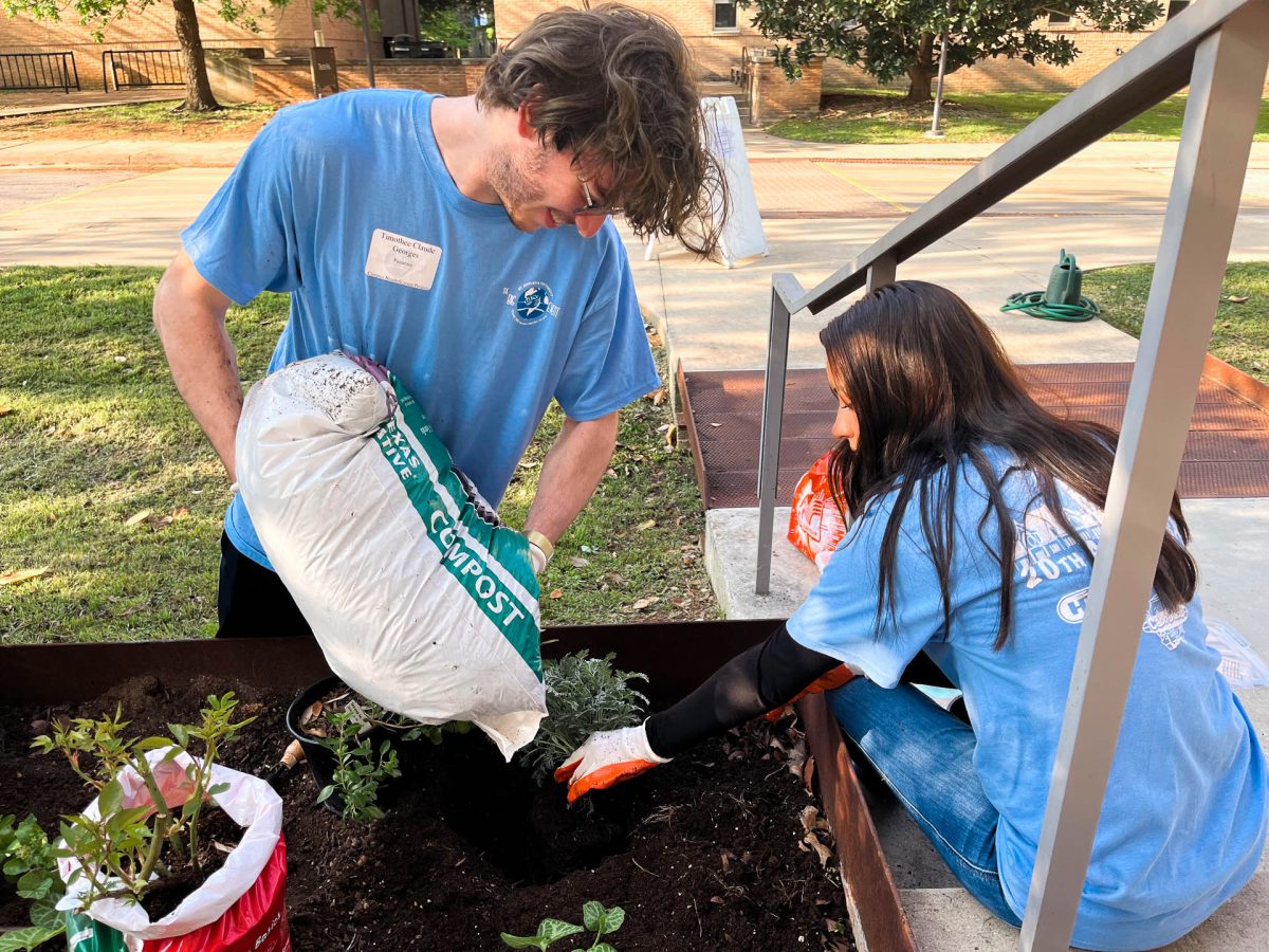 Junior Timothee Pommier and junior Andrea Ochoa planting flowers in front of Our Lady Queen of Peace Chapel.
