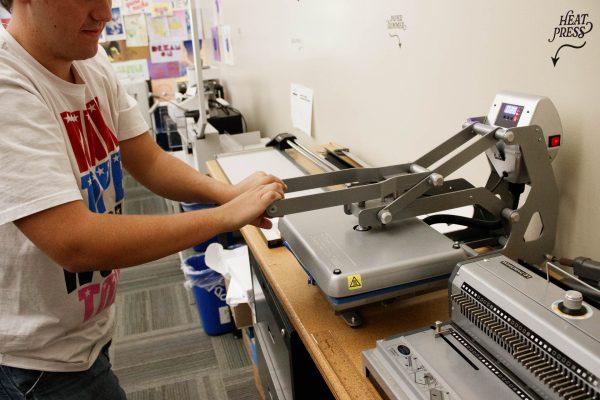 Here is Liam Molina, a graphic design major using the heat press to transfer his design to the pencil. “We hold this event to show the students how to use the heat press and we would like to see them make their own design and heat press it,” Perea said. 