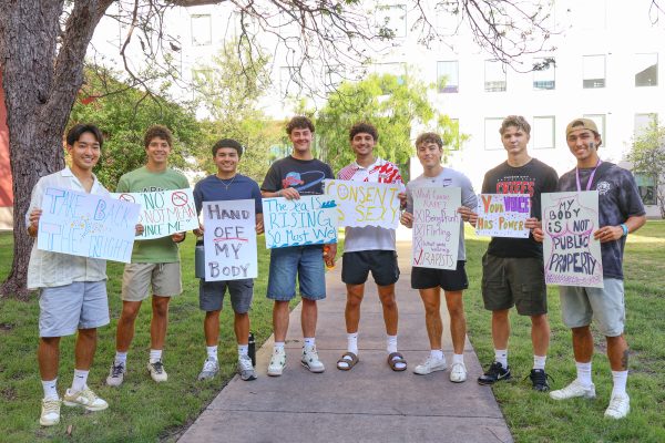 Players from the St. Edward’s Men’s Soccer team pose for a photo while holding signs made at the It’s On Us poster and bracelet making event a few nights before Take Back the Night. 